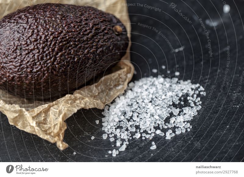 Avocado Frucht frisch violett dunkel Haut knittern Falte reif Salz Grob Meersalz Papier braun Farbfoto Menschenleer Lebensmittel Kochsalz Essen Foodfotografie