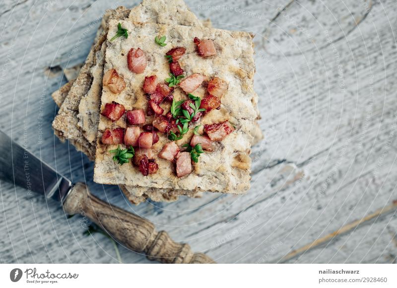 Knäckebrot mit Speckstückchen Speckstücke gewürfelt hardbread gebraten rustikal frisches Brot braun weiß Kresse Gartenkresse Mittagessen Holztisch Speckwürfel