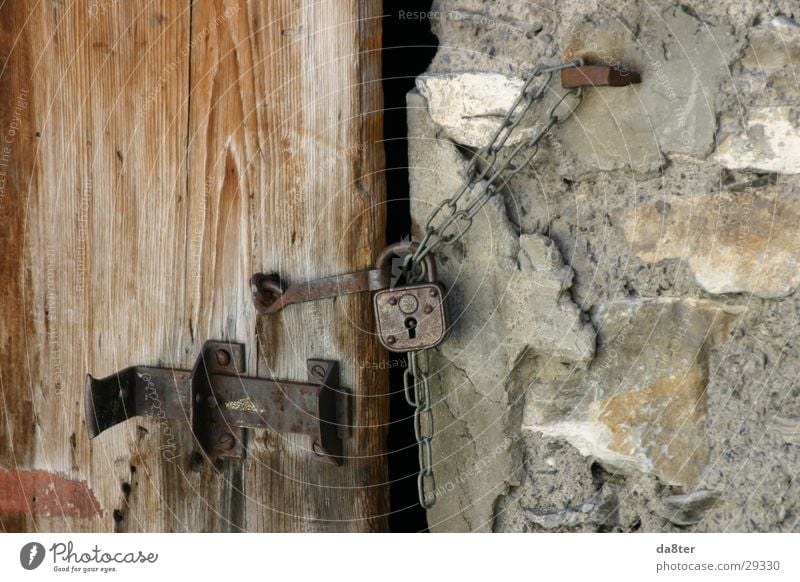 Altes Türschloß Türschloss Riegel Vorhängeschloss Mauer Wand Holztür Steinwand Burg oder Schloss Kette alt