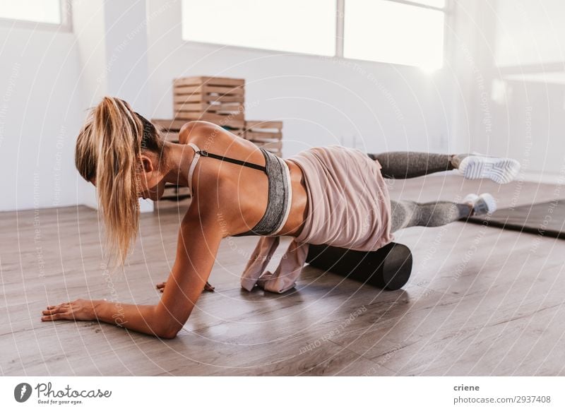 Frau mit Schaumstoffrolle im Fitnessstudio Lifestyle Stil schön Körper Sport Yoga Erwachsene sitzen sportlich dünn hell Kraft Konzentration Faszien üben