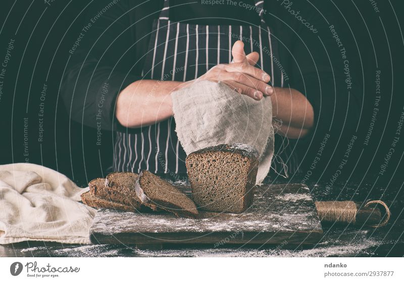 Chefkoch in schwarzem, einheitlich geschnittenem, gebackenem Roggenbrot Brot Ernährung Essen Mittagessen Abendessen Diät Tisch Küche Mann Erwachsene Hand