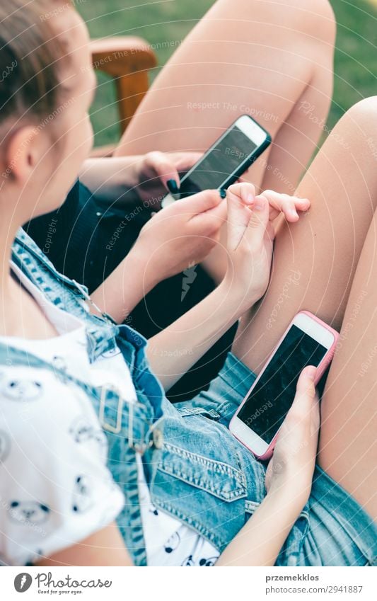 Junge Frauen, die Mobiltelefone benutzen und sich einen Musikclip ansehen. Lifestyle Sommer sprechen Telefon Handy PDA Technik & Technologie Erwachsene