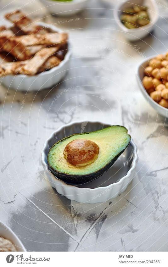 Avocado halbiert sich auf dem Tisch Lebensmittel Fleisch Gemüse Frucht Ernährung Essen Frühstück Mittagessen Bioprodukte Vegetarische Ernährung Diät exotisch