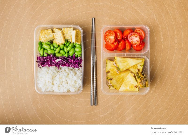 Gesunde vegane Bento-Box im asiatischen Stil flache Verlegung Kirschtomaten geschnitten Ananas Rotkohl geschmackvoll grün Essen zubereiten Metallstäbchen