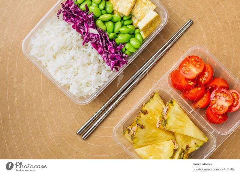 Gesunde vegane Bento-Box im asiatischen Stil flache Verlegung Kirschtomaten geschnitten Ananas Rotkohl geschmackvoll grün Essen zubereiten Metallstäbchen