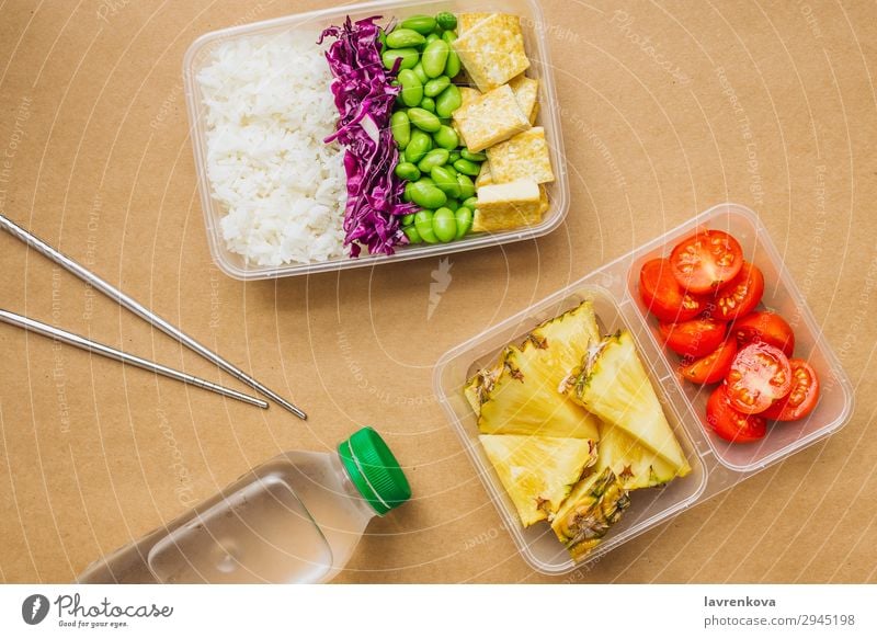 Gesunde vegane Bento-Box im asiatischen Stil grün Flasche Wasser flache Verlegung Kirschtomaten geschnitten Ananas Rotkohl geschmackvoll Essen zubereiten