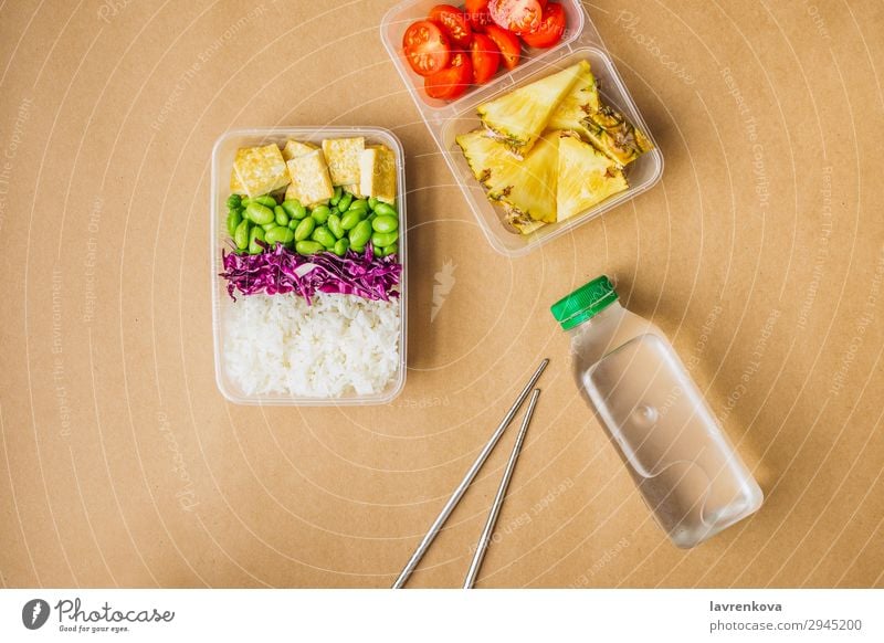 Gesunde vegane Bento-Box im asiatischen Stil grün Flasche Wasser flache Verlegung Kirschtomaten geschnitten Ananas Rotkohl geschmackvoll Essen zubereiten