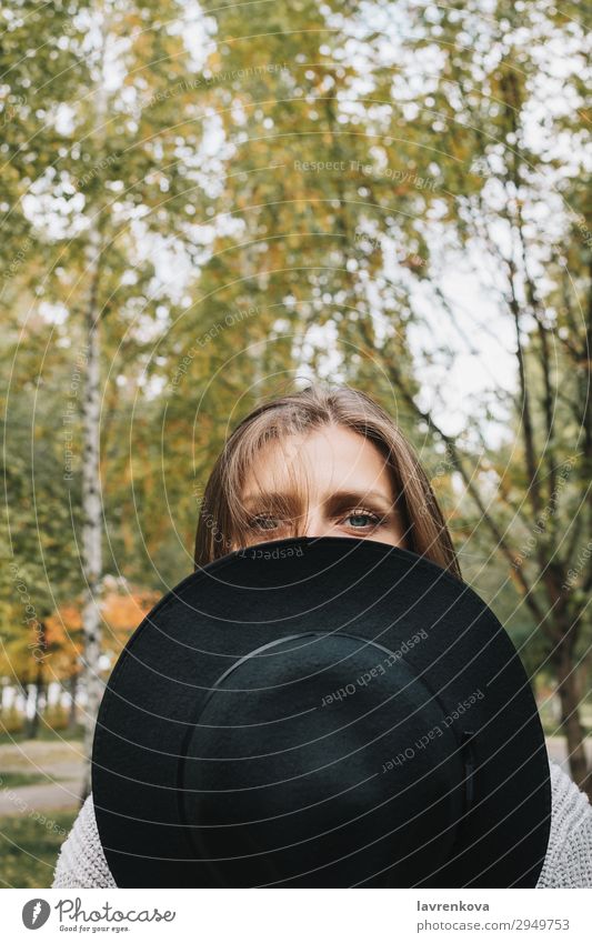 Frau, die die Hälfte ihres Gesichtshutes bedeckt. Herbst Mode Hipster Porträt Auge Behaarung Erwachsene niedlich Einsamkeit gesichtslos Wald Hut Blatt Lifestyle