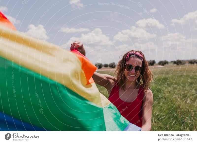 Frau hält die Gay Rainbow Flag auf einer grünen Wiese im Freien. Lifestyle Freude Glück Freizeit & Hobby Freiheit Sommer Sonne Hochzeit Mensch feminin