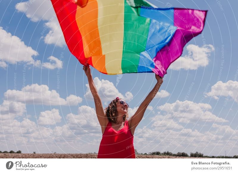 Frau hält die Gay Rainbow Flag über dem blauen Himmel. Lifestyle Freude Glück Freizeit & Hobby Freiheit Sommer Sonne Hochzeit Mensch feminin Homosexualität