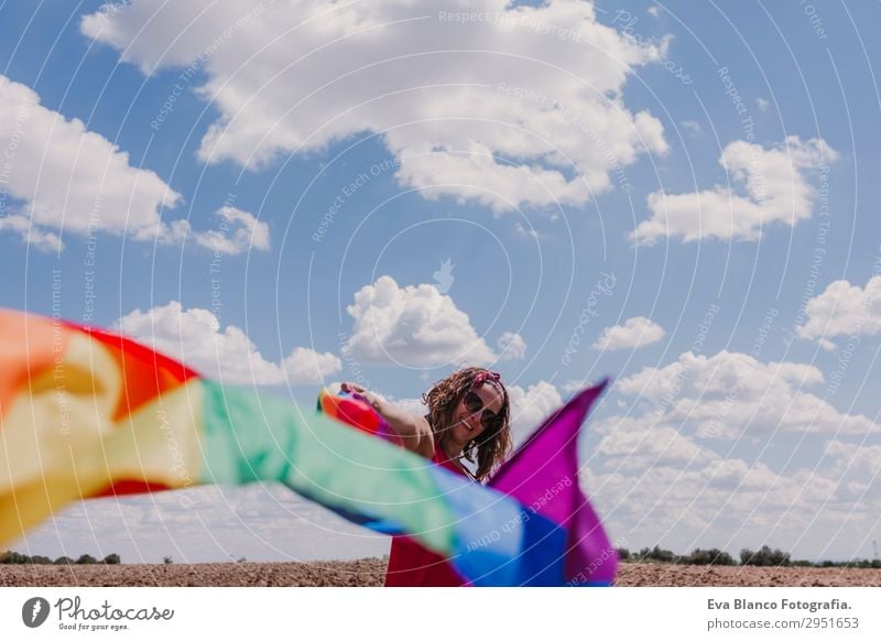 Frau hält die Gay Rainbow Flag über dem blauen Himmel im Freien. Lifestyle Freude Glück Freizeit & Hobby Freiheit Sommer Sonne Hochzeit Mensch feminin