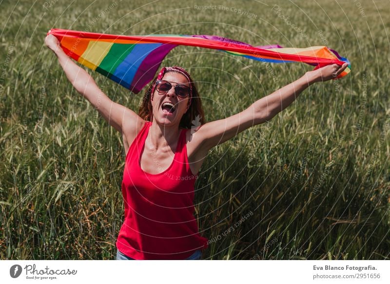 Frau hält die Gay Rainbow Flag auf einer grünen Wiese im Freien. Lifestyle Freude Glück Freizeit & Hobby Freiheit Sommer Sonne Hochzeit Mensch feminin