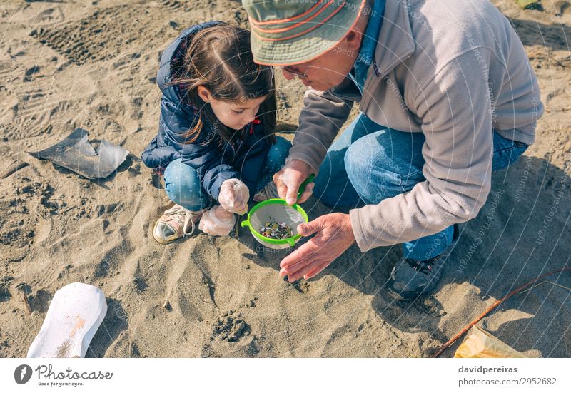 Freiwillige beim Putzen des Strandes Kind Arbeit & Erwerbstätigkeit Mensch Frau Erwachsene Mann Großvater Familie & Verwandtschaft Umwelt Sand Hut Sieb