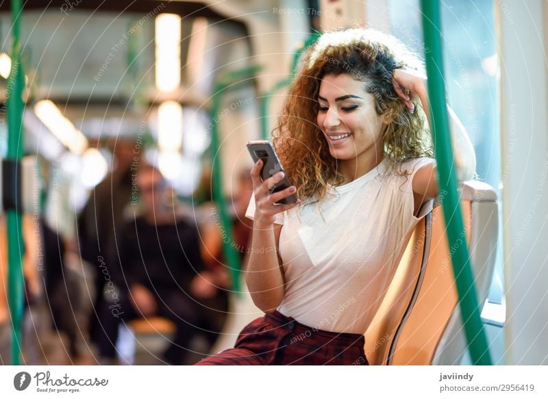 Arabische Frau in der U-Bahn schaut auf ihr Smartphone. Lifestyle Glück schön Haare & Frisuren Ferien & Urlaub & Reisen Tourismus Ausflug Telefon PDA Mensch