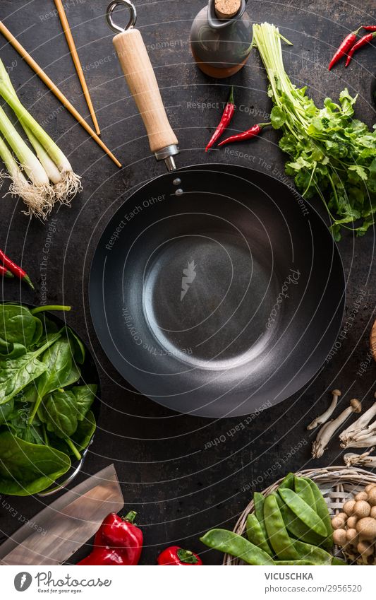 Leere Wok-Pfanne auf dem Küchentisch mit Essstäbchen und vegetarischen asiatischen Lebensmittelzutaten, Ansicht von oben. Platz zum Kopieren.  Gesundes Essen und Kochen