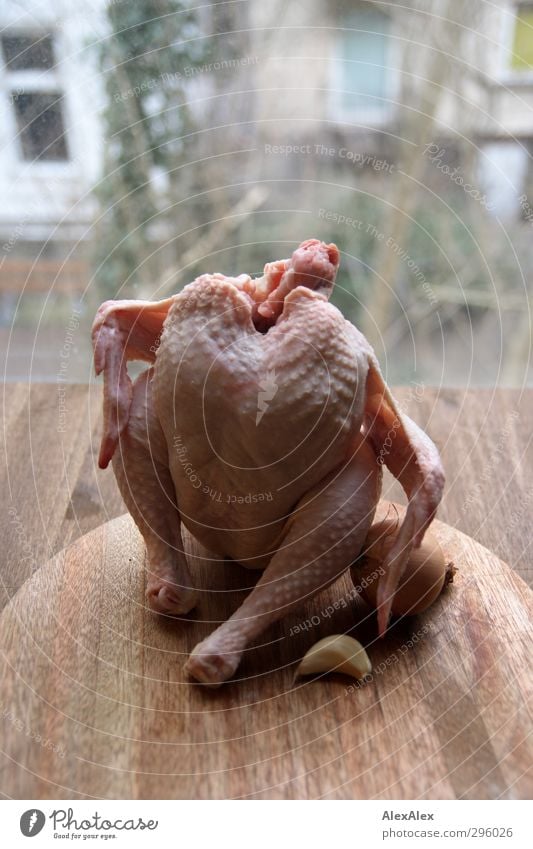 Nacktportrait mit Zwiebel und Knoblauch - kopflos Lebensmittel Fleisch Suppenhuhn Ernährung Abendessen Bioprodukte Schneidebrett Holztisch sitzen authentisch