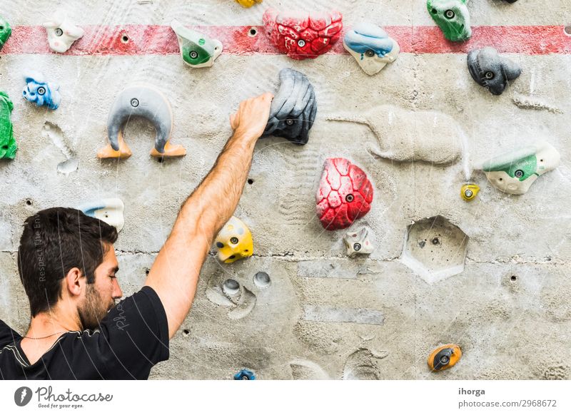 Mann übt Klettern an einer künstlichen Wand in Innenräumen. Lifestyle Freude Freizeit & Hobby Sport Bergsteigen maskulin Junger Mann Jugendliche Erwachsene Hand