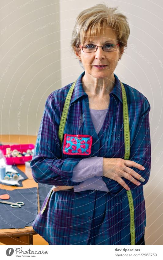 Senior-Schneiderin posiert mit Nähmaterialien Lifestyle Design Freizeit & Hobby Tisch Handwerk Business Mensch Frau Erwachsene Mode Bekleidung Stoff alt Lächeln