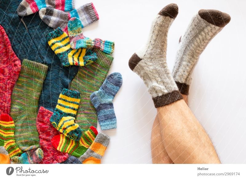 Bunte Socken auf weissem Hintergrund und ein Paar Männerbeine Stil Design Handarbeit stricken Winter Mensch maskulin Mann Erwachsene Beine Fuß 1 30-45 Jahre