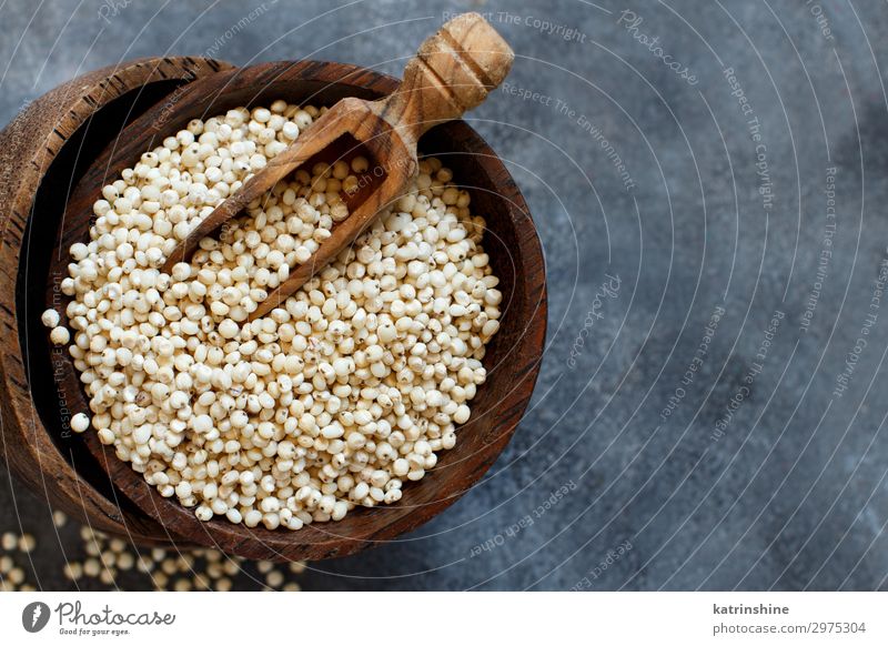 Rohweißes Sorghumkorn Gemüse Vegetarische Ernährung Diät Schalen & Schüsseln Löffel natürlich grau Korn Müsli roh Textfreiraum Samen rustikal Holz