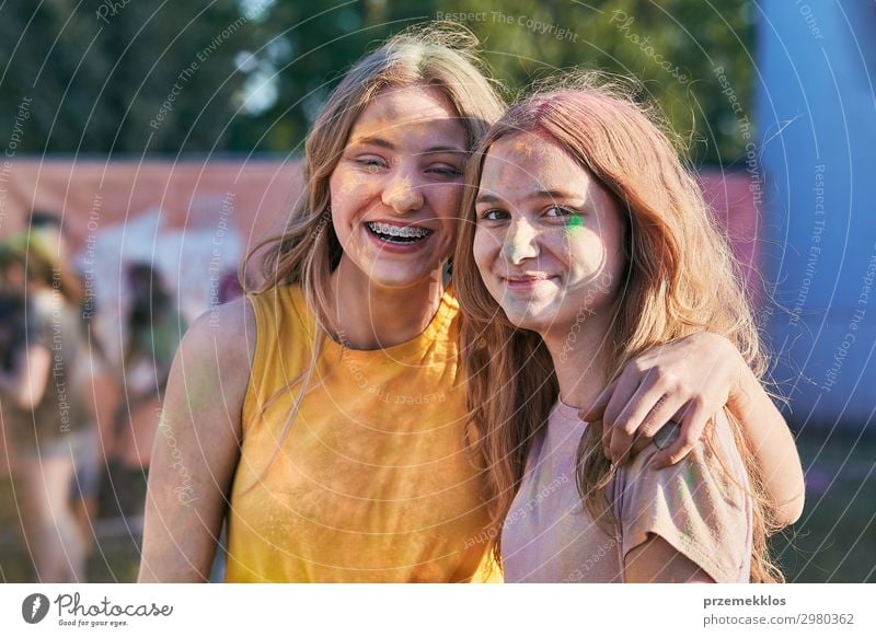 Porträt der glücklich lächelnden jungen Mädchen mit bunten Farben auf Gesichtern und Kleidung. Zwei Freunde verbringen Zeit auf holi Farbe Festival Lifestyle