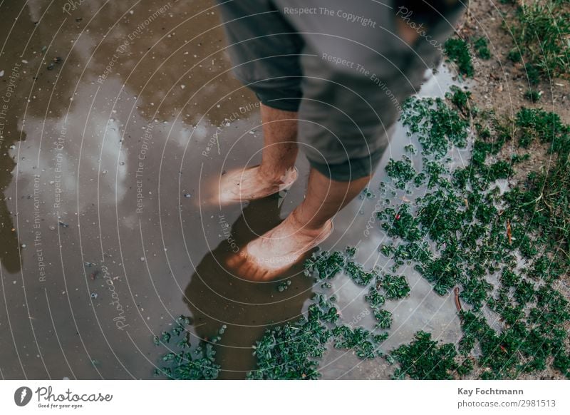 feet of a man standing inside a big puddle after a heavy rain Lifestyle Ferien & Urlaub & Reisen Tourismus Sommer Sommerurlaub Mensch maskulin Leben Beine Fuß 1