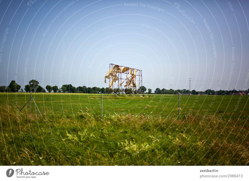 Hier könnte Ihre Werbung stehen! Werbebranche Transparente Außenaufnahme Umgebung Information Gestell Rahmen kaputt Wind wehen verweht Wiese Gras Weide Horizont