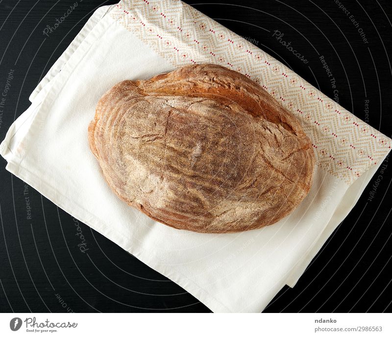 gebackenes ovales Roggenbrot Brot Ernährung Essen Tisch Küche Holz dunkel frisch natürlich braun schwarz Bäckerei Holzplatte Kruste Mehl Lebensmittel Korn