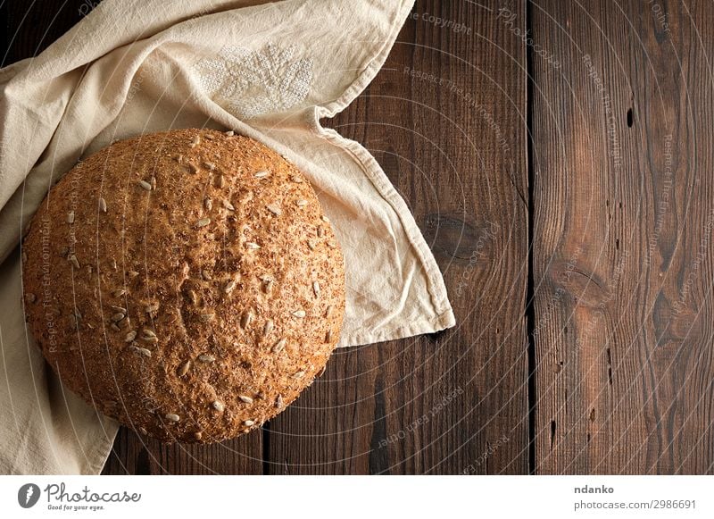 gebackenes rundes Roggenbrot mit Sonnenblumenkernen Brot Brötchen Ernährung Essen Frühstück Diät Tisch Holz dunkel frisch lecker natürlich oben braun Tradition