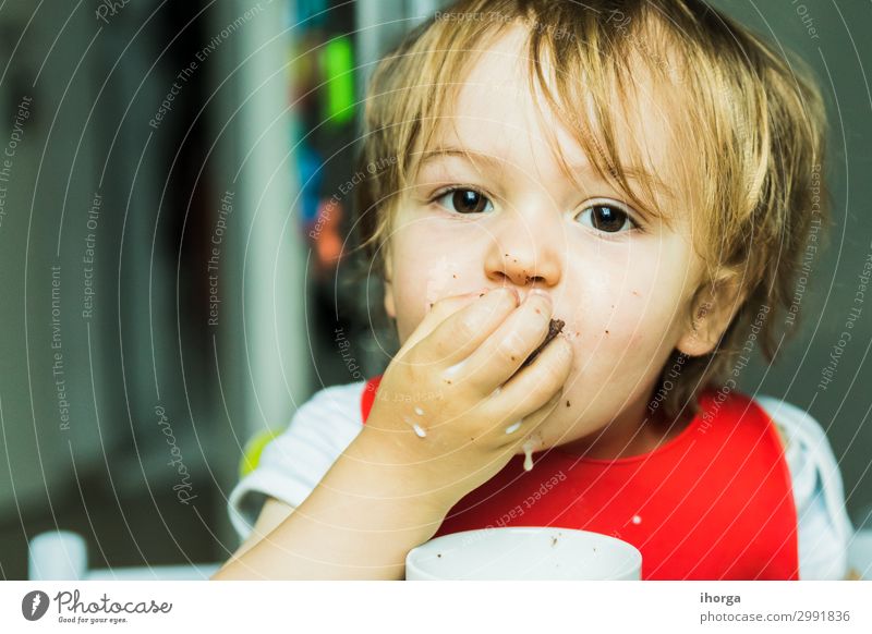 Porträt bezauberndes Kind isst Schokolade Biskuitkuchen Essen Milch Baby Junge Kindheit Gesicht Hand 1 Mensch 1-3 Jahre Kleinkind Lächeln dreckig klein lecker