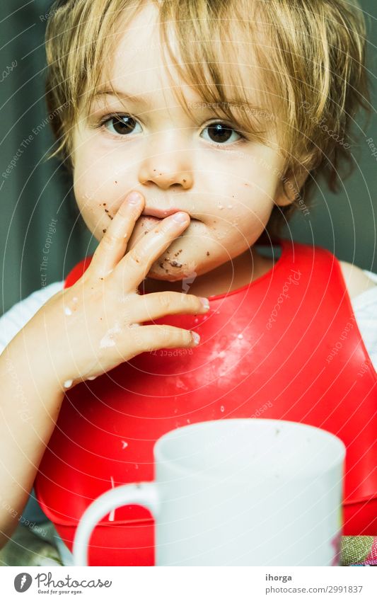 Porträt bezauberndes Kind isst Schokolade Biskuitkuchen Attribut Baby Hintergrund Lätzchen Junge braun Kuchen Bonbon Kindheit schoko niedlich lecker wüst