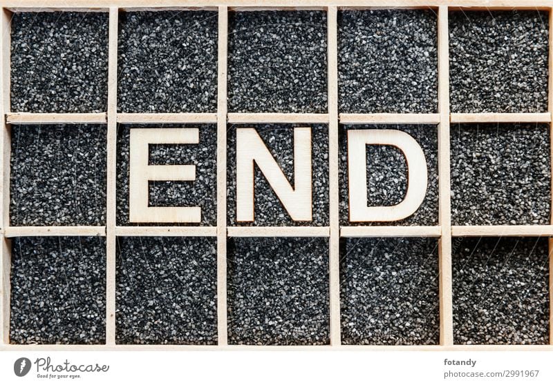 Wooden word END on black sand Holz Zeichen Schriftzeichen Hinweisschild Warnschild braun schwarz weiß Ende Kreativität Ordnung Trennung Wissen Buchstaben