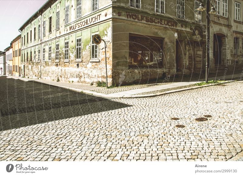 Spitzkehre Kleinstadt Haus Ruine Bauwerk Gasthof Fassade Straße Straßenkreuzung Kopfsteinpflaster Straßenecke Schatten Schlagschatten alt dunkel Spitze trist