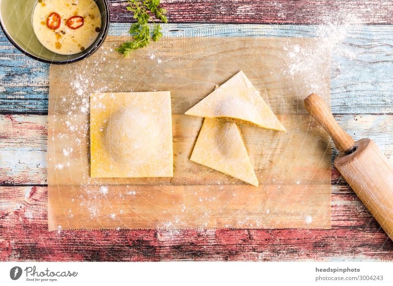 Selbsgemachte Tortelloni auf buntem Holztisch Lebensmittel Teigwaren Backwaren Ernährung Mittagessen Abendessen Festessen Slowfood Italienische Küche