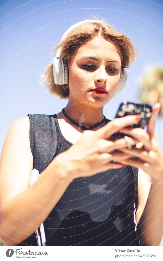 Ein blondes junges Mädchen mit einem elektronischen Gerät. Lifestyle Mensch feminin Junge Frau Jugendliche 1 18-30 Jahre Erwachsene Telefongespräch Farbfoto Tag