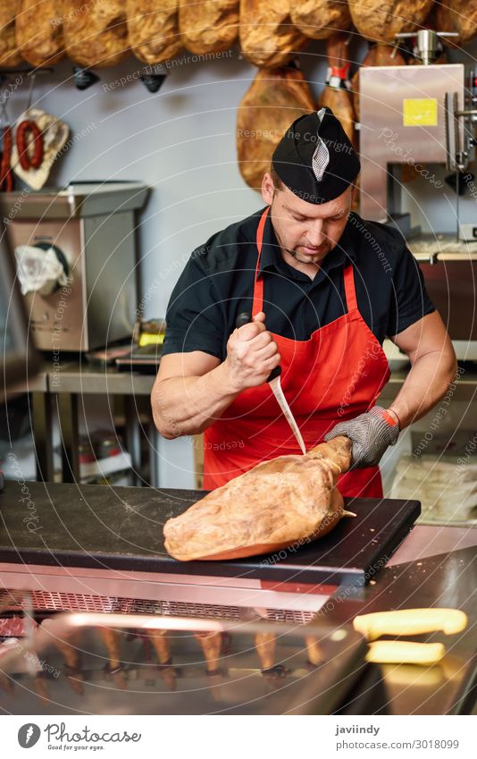 Metzger beim Entbeinen eines Schinkens in einer modernen Metzgerei Lebensmittel Fleisch kaufen Arbeit & Erwerbstätigkeit Beruf Business Mensch Mann Erwachsene 1