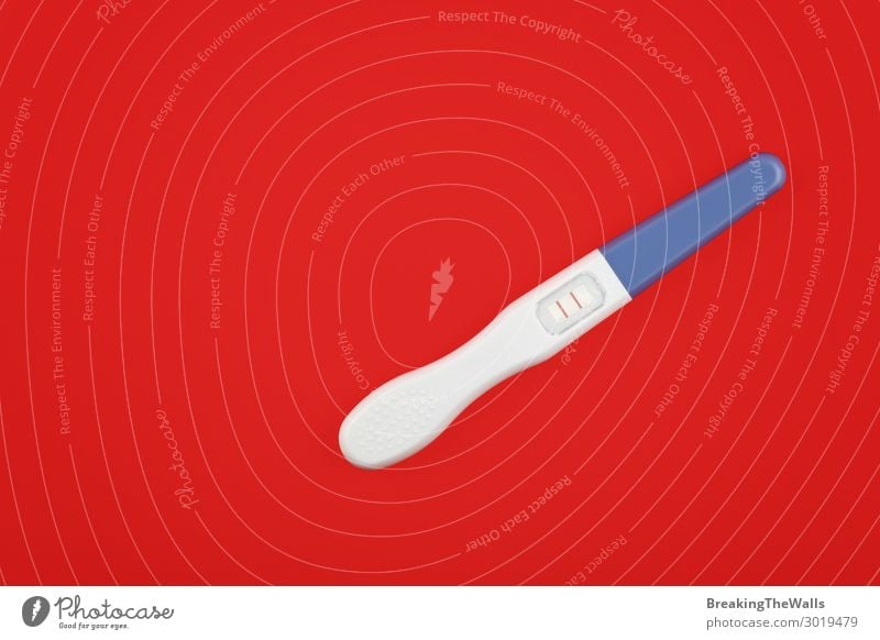 Nahaufnahme eines positiven Schwangerschaftstests über rot Gesundheit Gesundheitswesen Medikament Streifen Erfolg oben schwanger Freude Fröhlichkeit Vorfreude
