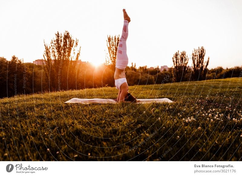 junge schöne asiatische Frau, die Yoga in einem Park bei Sonnenuntergang macht. Lifestyle Glück Körper harmonisch Erholung Meditation Sommer Musik Sport Mensch