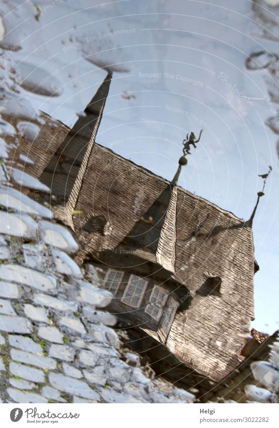 Spiegelung eines Historischen Gebäudes in einer Pfütze auf dem Kopfsteinpflaster Stadt Turm Bauwerk Architektur Fenster Dach Straße Stein außergewöhnlich