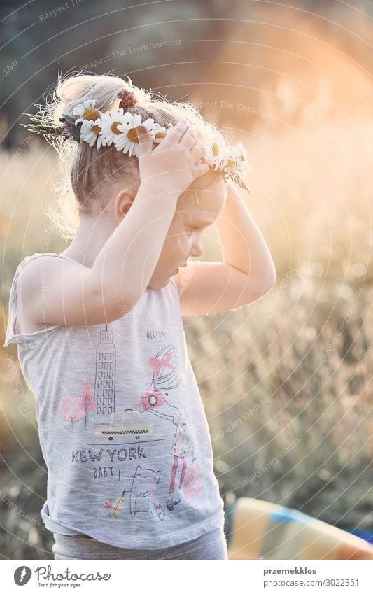 Kleines Mädchen trägt einen Krönchen aus Wildblumen auf dem Kopf. Lifestyle Freude Glück Erholung Freizeit & Hobby Spielen Ferien & Urlaub & Reisen Sommer Kind