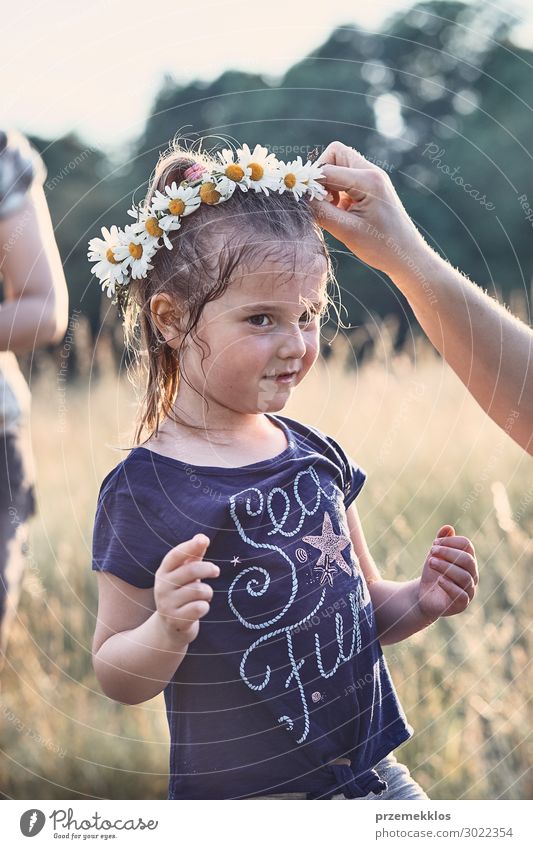 Mutter setzt einen Krönchen aus Wildblumen auf den Kopf eines Mädchens. Lifestyle Freude Glück Erholung Freizeit & Hobby Ferien & Urlaub & Reisen Sommer