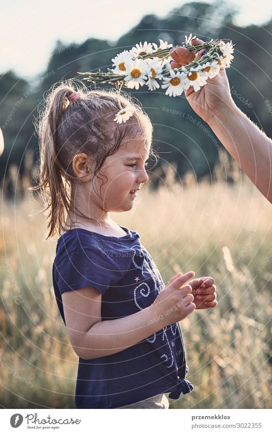 Mutter setzt einen Krönchen aus Wildblumen auf den Kopf eines Mädchens. Lifestyle Freude Glück Erholung Freizeit & Hobby Ferien & Urlaub & Reisen Sommer