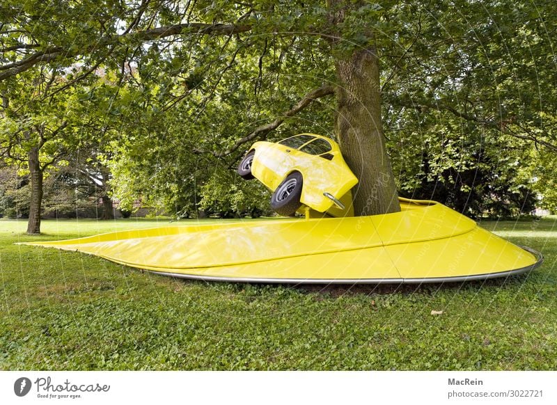 Modifiziertes Auto um einem Baum gewickelt Kunst Ausstellung Kunstwerk Garten Park Wiese Fahrzeug PKW alt retro gelb gekrümmt umwickelt wickeln Design Farbfoto