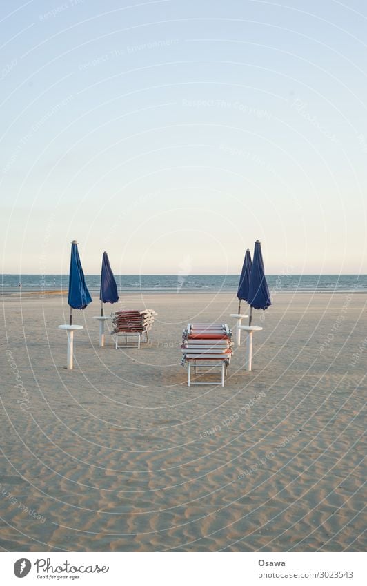 gestapelte Sonnenliegen und geschlossene Sonnenschirme am Strand Meer Küste Sand Ferien & Urlaub & Reisen Sommer Außenaufnahme Sommerurlaub Schönes Wetter