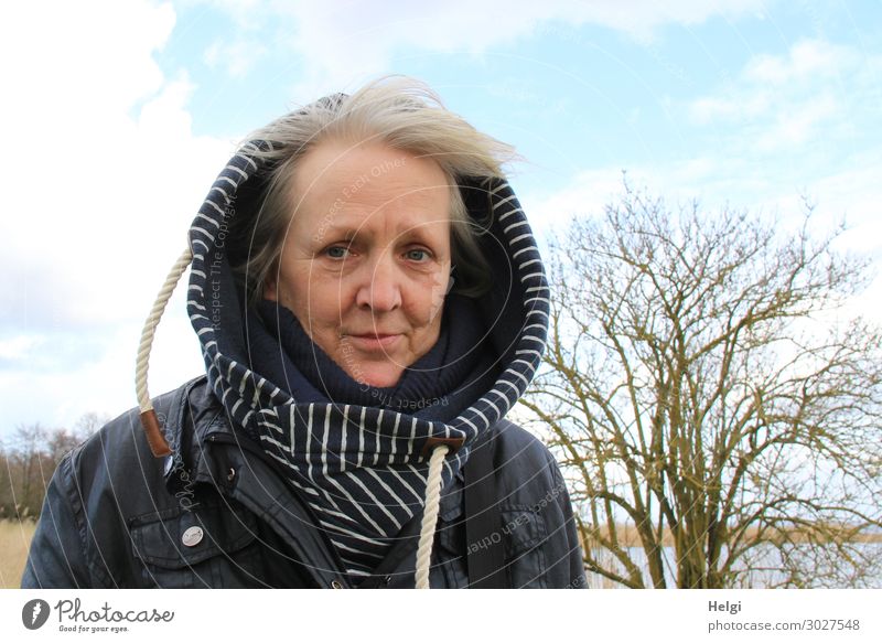 Seniorin mit Kapuzenjacke steht bei schönem Wetter draußen im Wind Mensch feminin Frau Erwachsene Weiblicher Senior 1 60 und älter Umwelt Natur Pflanze Frühling