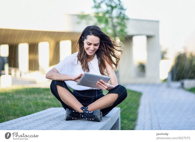 Junge Frau, die ein digitales Tablet benutzt und im städtischen Hintergrund im Freien sitzt. Lifestyle Glück schön lesen Studium Arbeit & Erwerbstätigkeit Beruf