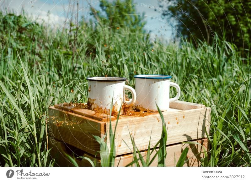 Emailbecher mit Kaffee oder Tee auf einer Holzkiste Frühling Gras Außenaufnahme Getränk trinken Geplätscher heiß Tasse Emaille Picknick wandern Sommer Natur