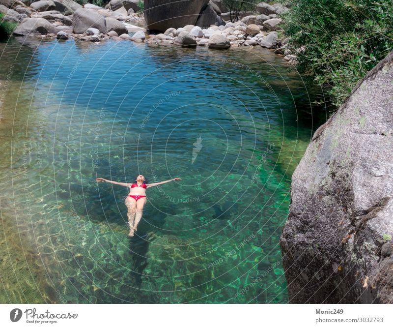 Frau mit rotem Bikini, die in einem Fluss schwimmt. Lifestyle exotisch Freude Körper Schwimmbad Ferien & Urlaub & Reisen Tourismus Sommer Sonne Berge u. Gebirge