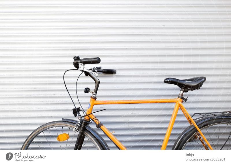 Herrenfahrrad Menschenleer Lamelle Garagentor Fahrradfahren Metall Linie Streifen einfach gelb schwarz weiß angelehnt davor stehen parken Abstellplatz Farbfoto