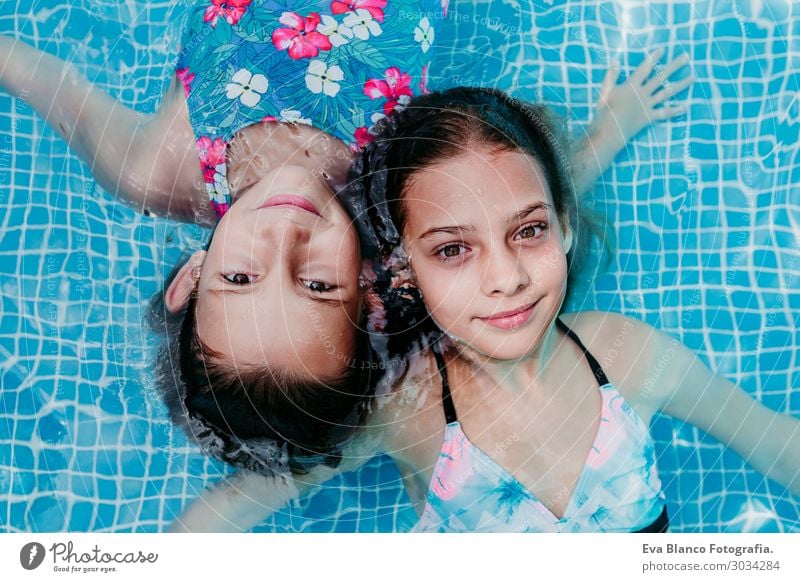 zwei schöne Teenagermädchen, die in einem Pool schwimmen. Lifestyle Freude Glück Erholung Schwimmbad Freizeit & Hobby Ferien & Urlaub & Reisen Sommer Sonne